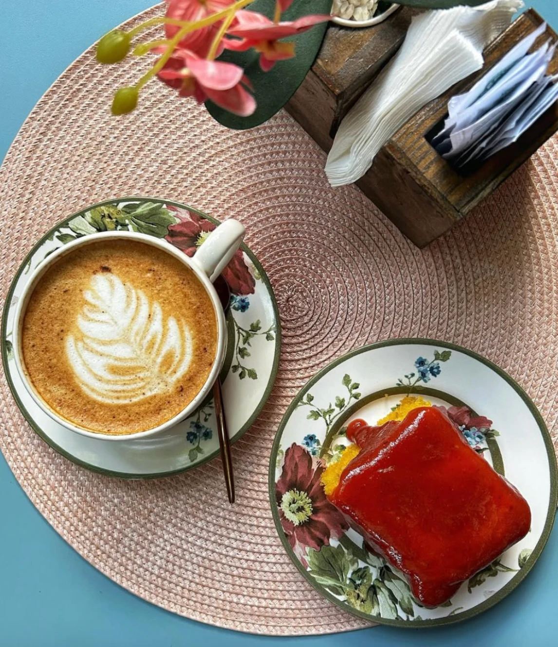 Cappuccino com latte art e fatia de bolo de milho com calda de goiabada